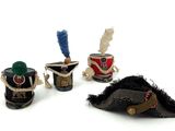 three miniature hats and a pipe are sitting on a white surface