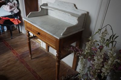 un bureau en bois avec un plateau en marbre dans un salon