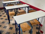 tables and chairs are lined up in a room with a checkered floor