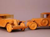 two wooden toy cars sitting side by side on a table