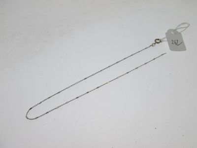 une photo d'un collier en argent auquel est accrochée une étiquette