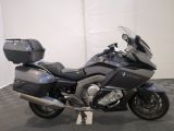 bmw motorcycle parked in a showroom with its luggage strapped on the back