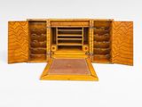 une petite boîte en bois dont la porte s'ouvre sur une surface blanche
