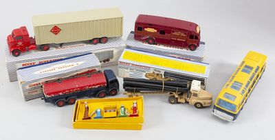 beaucoup de camions miniatures et un bus posés sur une surface blanche
