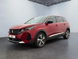 Une voiture rouge est garée dans une grande pièce au sol noir.