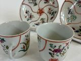 three cups and a saucer sitting on a table