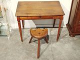 a small wooden desk with a stool in front of it