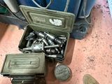 une valise remplie d'outils posée par terre à côté d'une paire de chaussures