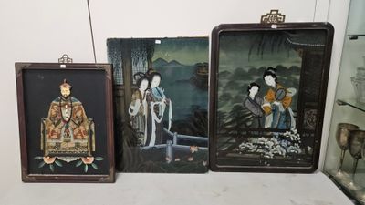 trois tableaux asiatiques encadrés, exposés sur une étagère dans une vitrine