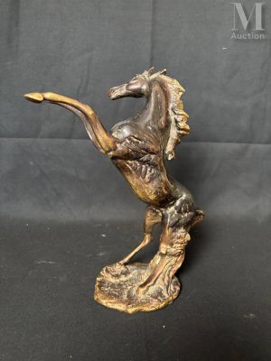 a bronze statue of a horse on a rock on a black background