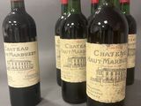 trois bouteilles de vin rouge sont alignées sur une table