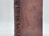 an old book sitting on top of a white surface