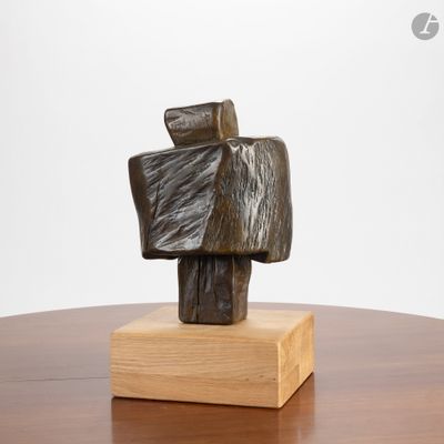 une sculpture représentant un homme tenant un morceau de bois posé sur une table