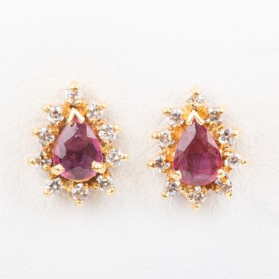 a pair of ruby and diamond earrings on a white background