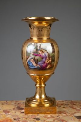 un vase en or orné d'une peinture, posé sur une table