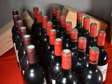 many bottles of wine sitting on a red table cloth