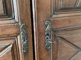 pair of antique wooden doors with metal handles in a room