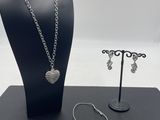 a close up of a necklace, bracelet, and bracelet holder on a table