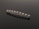 a close up of a hair pin with diamonds on a black surface