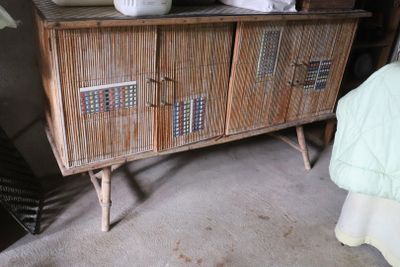 a wooden cabinet with two baskets on top of it