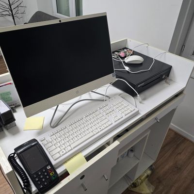 un bureau sur lequel se trouvent un ordinateur, un téléphone et d'autres objets
