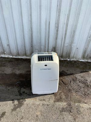 a small white air conditioner sitting outside of a building