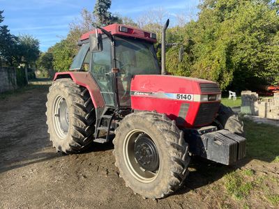 un tracteur rouge garé sur le bord de la route