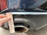 a person holding a measuring tape next to a car