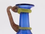 a blue glass vase with a snail on top of it