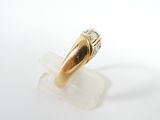 an image of a gold and diamond ring sitting on top of a clear piece of plastic