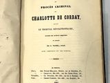 un livre ouvert posé sur une table, à côté d'une nappe blanche