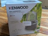 un carton contenant un mixeur Kenwood posé sur une table en bois