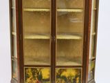 une vitrine ancienne dotée de deux portes vitrées et ornée d'un motif floral sur la façade