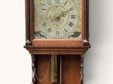 a clock that is hanging on the wall with angels on it