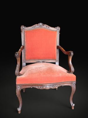 an old chair with a red upholstered seat on a black background