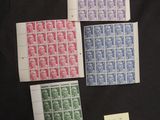 four different colored stamps are on a black surface