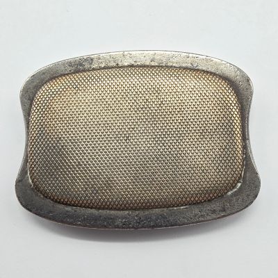 une boucle ancienne en argent, ornée d'un motif en mailles sur fond blanc