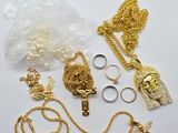 several gold chains, rings, rings, and other jewelry on a white surface