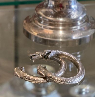 a silver snake that is sitting on top of a glass table