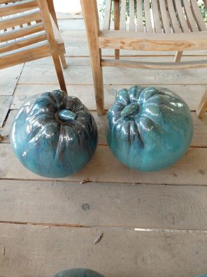 deux citrouilles bleues posées sur un perron, à côté d'une chaise en bois