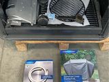 a grill with a grill cover on it next to a box of items
