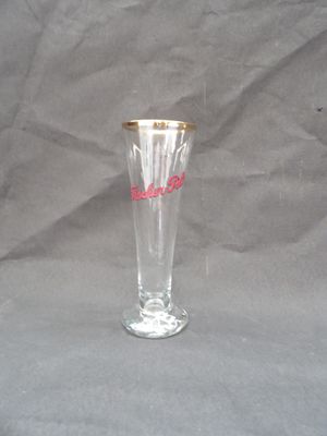 a clear glass with a gold rim sitting on a gray surface