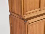 a tall wooden cabinet with two doors on top of it