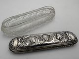 a silver case and a glass bottle on a table
