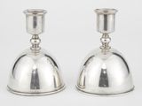 une paire de chandeliers en argent sur fond blanc