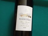 une bouteille de vin et un cigare posés sur une table de billard