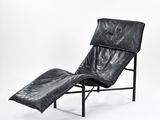 chaise longue en cuir noir avec structure en métal noir et repose-pieds