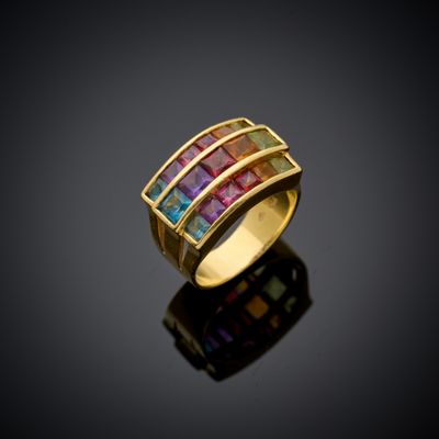 une bague en or sertie de pierres multicolores sur un fond noir