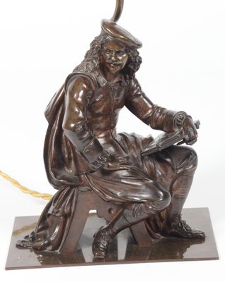 une image représentant une statue en bronze d'un homme assis sur un rocher