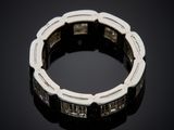 a white gold and diamond ring on a black surface